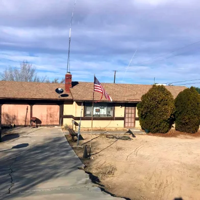 House We Bought With Cracked Driveway And Torn Flag Out Front